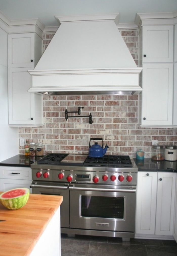 awesome freestanding oven stove under curvy white wooden hood and shabby brick kitchen backsplash Домострой